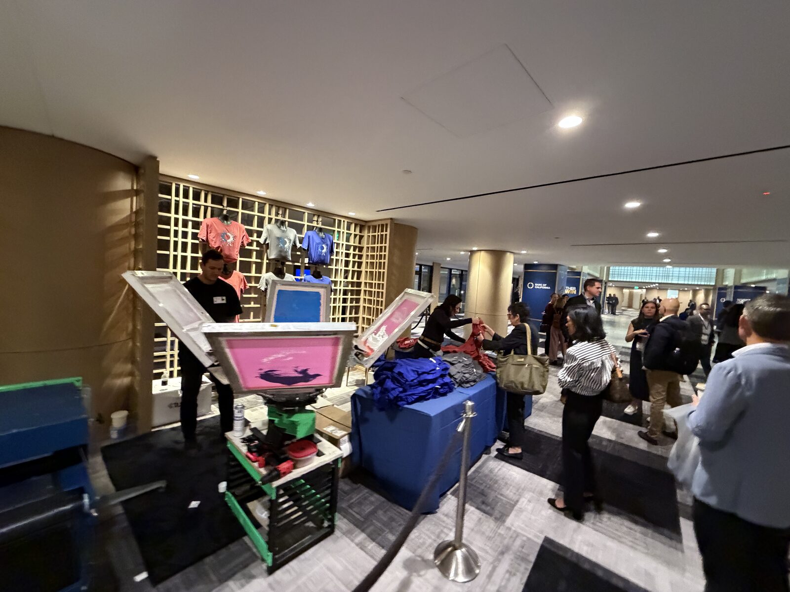 A branded corporate event printing booth staffed by the Merch Troop crew