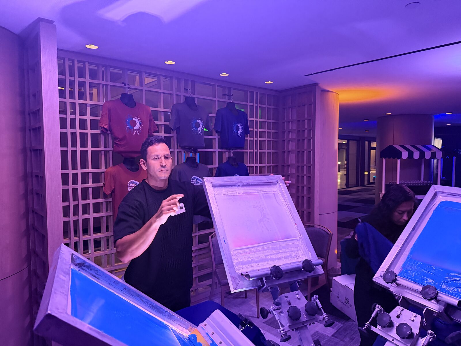 Screen printing presses glowing at a nighttime event station