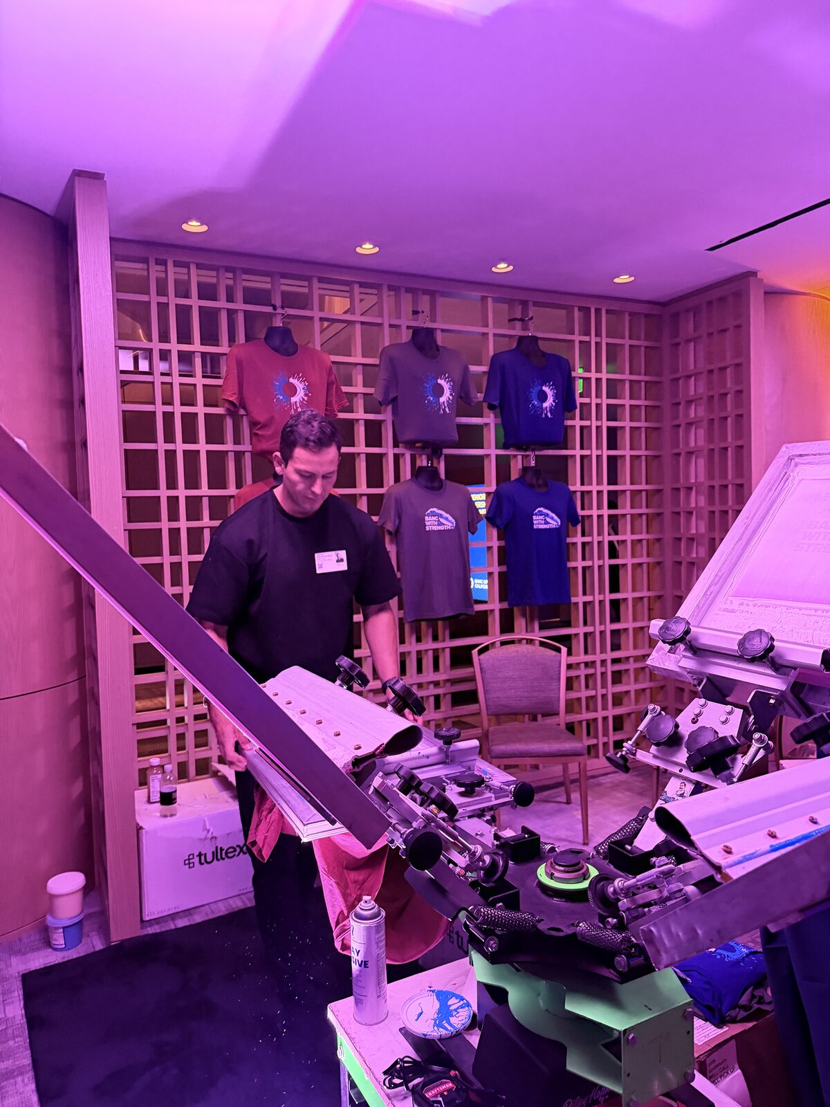 An operator loading a blank shirt onto a screen press before an event