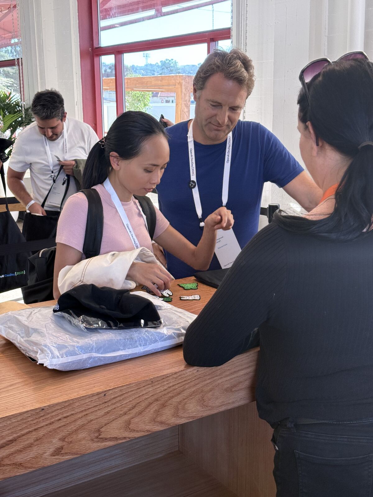 Event staff interacting with customers wearing lanyards at an indoor event booth